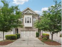 Charming townhome featuring a brick facade, two-car garage, a bay window, and a well maintained front yard at 3949 Glenview Club Ln, Duluth, GA 30097