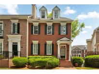 Charming brick townhome with well-maintained landscaping, black shutters, and a welcoming entrance at 4676 Ivygate Se Cir, Atlanta, GA 30339