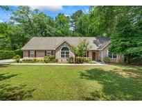 Charming home with a well-manicured lawn, inviting facade, and mature trees at 55 Fox Chase, Covington, GA 30016