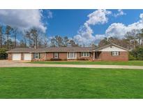 Charming brick home featuring an attached two-car garage and a well-maintained lawn at 2716 Georgia 16, Carrollton, GA 30116