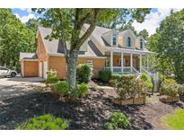Charming two-story brick home with a welcoming front porch and lush, mature landscaping at 2936 Summitop Ne Rd, Marietta, GA 30066