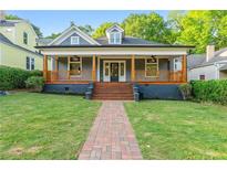 Charming home featuring a covered porch with wooden details and a brick pathway leading to the entrance at 378 Grant Park Pl, Atlanta, GA 30315