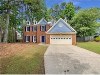 Charming two-story brick home with blue shutters, white trim, and a spacious two-car garage at 6370 Maid Marion Close, Alpharetta, GA 30005