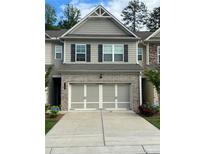 Charming townhome featuring a two-car garage and gray siding with black shutters at 6780 Cedar Glen Rd, Peachtree Corners, GA 30360