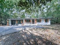 Charming ranch-style home with a freshly painted exterior, mature trees, and a covered porch at 221 Wonewok Dr, Canton, GA 30114