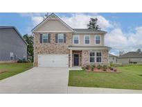 Charming two-story home featuring a brick facade, neutral siding, and an attached two-car garage at 320 Tulip Dr, Covington, GA 30016