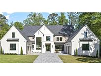Stunning new construction home with a white brick facade, elegant trim, and a spacious three-car garage at 4785 Merlendale Ct, Atlanta, GA 30327