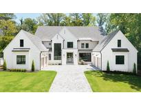 Stunning two-story home with a manicured lawn and a symmetrical facade showcasing a modern design at 4785 Merlendale Ct, Atlanta, GA 30327