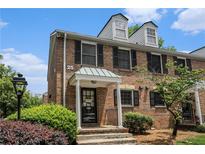 Charming brick townhome featuring black shutters, dormer windows, and a welcoming covered entrance at 6700 Roswell Ne Rd # 25A, Sandy Springs, GA 30328