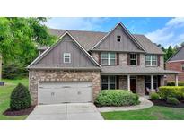 Two-story brick home with a two-car garage and well-maintained landscaping at 1370 Sunnys Halo Dr, Suwanee, GA 30024