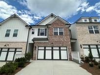 Charming townhome with brick facade, white siding, and a two-car garage at 257 Depot Landing Rd # 39, Auburn, GA 30011