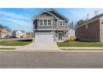 Charming two-story home with gray siding, white trim, and a two-car garage in a suburban neighborhood at 266 Tulip Dr, Covington, GA 30016