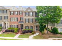 Charming townhome featuring a landscaped front yard and a welcoming entrance with a brick facade and decorative shutters at 3857 Felton Hill Sw Rd # 9, Smyrna, GA 30082
