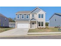 Charming two-story home featuring a two-car garage, manicured lawn, and inviting front porch at 107 St Annes Pl, Covington, GA 30016