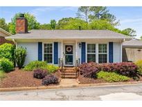Charming home featuring a brick chimney, blue shutters, and well-maintained landscaping at 1140 Moorestown Cir, Decatur, GA 30033