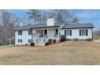 Charming exterior view of a two-story home with a well-maintained lawn and inviting front porch at 2885 Green Rd, Loganville, GA 30052