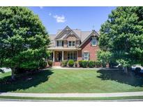 Beautiful two-story brick home with a well-manicured lawn and mature trees at 737 Heritage Post Ln, Grayson, GA 30017