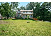 Charming two-story home with a well-manicured lawn and mature trees, creating a welcoming curb appeal at 3664 Nessa Se Ct, Smyrna, GA 30082