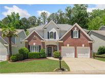 Charming two-story brick home featuring a well-manicured lawn and an attached two-car garage at 4018 Rhyne Se Cir, Smyrna, GA 30082