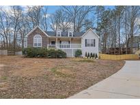 Charming home with stone accents, a cozy front porch, and manicured landscaping at 954 Josie Ct, Lawrenceville, GA 30045