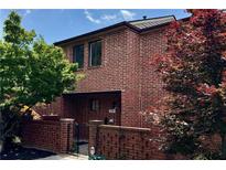 Charming brick townhouse featuring mature trees and an inviting gated entryway, offering a warm welcome at 2259 Pernoshal Ct, Dunwoody, GA 30338