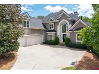 Stunning two-story traditional home with a three-car garage and a grand arched entryway at 5860 Stoneleigh Dr, Suwanee, GA 30024