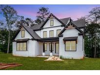 Beautiful white brick home features black trim and a covered front porch at 1072 Sweet Mia Ln, Powder Springs, GA 30127