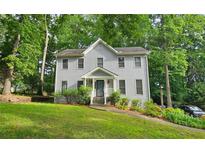 Charming two-story home with grey siding and a well-maintained front yard surrounded by lush trees at 2859 Wood Park Nw Trce, Kennesaw, GA 30152
