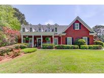 Charming brick home with a large front porch, lush landscaping, and a well-manicured lawn at 1292 Green Turf Dr, Snellville, GA 30078