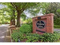 Brick sign for Willow Glen, a private community, surrounded by lush greenery, enhancing curb appeal at 49 Willow Gln, Atlanta, GA 30342