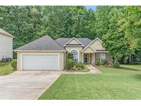 Charming single-story home with well-manicured lawn, attached garage, and lovely landscaping at 1335 Vine Cir, Mcdonough, GA 30253
