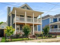 Charming two-story home featuring a double porch, fresh landscaping, and black iron fencing at 174 Crumley St, Atlanta, GA 30312