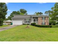 Charming two-story home with manicured lawn, attached garage, and inviting front porch at 1903 Lochlomand Se Ln, Smyrna, GA 30080