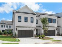 Exterior view of newly built townhomes featuring a two-car garage and manicured landscaping at 711 Dodd N Ln # 166, Buford, GA 30518