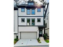 Beautiful three-story home with a gray garage door, white brick, black trim, and decorative door wreath at 1320 Stanley Park Dr # 141, Decatur, GA 30033
