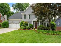 Charming two-story home with landscaped yard, a two-car garage, and a red front door at 4957 Day Lily Nw Way, Acworth, GA 30102