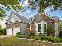Beautiful home with a stone facade, manicured landscaping, and a two-car garage on a sunny day at 613 Wiley Ct, Canton, GA 30115