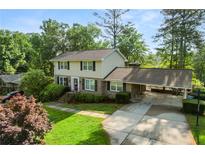 Charming two-story home with a brick facade, spacious driveway, well-manicured lawn, and inviting carport at 4379 Bonaparte Dr, Tucker, GA 30084