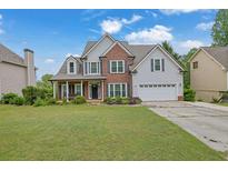 Charming two-story home with brick accents and a well-manicured lawn at 1663 Willow Way, Woodstock, GA 30188