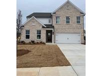 Charming two-story home showcasing a brick facade, a two-car garage, and a well manicured lawn at 1781 Jordan Brook Dr, Lawrenceville, GA 30043