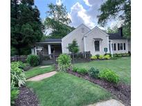 Charming home featuring a well-manicured lawn, wood fence, and beautiful landscaping at 574 Chicasaw Ne Dr, Marietta, GA 30060