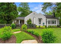 Charming home with stone walkway, lush landscaping, gray picket fence, and inviting curb appeal at 574 Chicasaw Ne Dr, Marietta, GA 30060