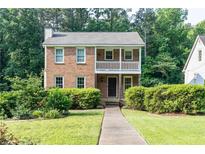 Charming brick home featuring a front porch, well-maintained landscaping and a welcoming walkway at 3112 Calumet Nw Cir, Kennesaw, GA 30152
