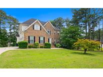 Charming two-story brick home with a well-manicured lawn and mature trees at 405 Branch Forest Way, Stockbridge, GA 30281