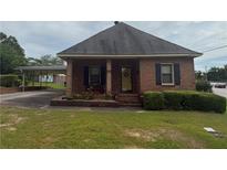 Charming brick home featuring a covered carport and a well-maintained front lawn and flower beds at 871 Malcom Se St, Conyers, GA 30012