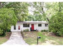 Charming single-story home featuring a bright red front door and a neatly maintained front lawn at 5904 Heatherwood Ln, Riverdale, GA 30296