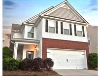 Charming two-story home with a brick and vinyl exterior, complemented by a two-car garage and well-maintained landscaping at 867 Crested Hawk Trl, Sugar Hill, GA 30518