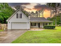 Charming single-Gathering home featuring a two-car garage, inviting front porch, and lush green lawn at 1959 Christian Circle, Conyers, GA 30013
