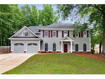 Charming two-story home with a well-manicured lawn, attached two-car garage, and mature trees at 3285 Country Walk Dr, Powder Springs, GA 30127