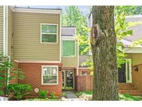 Two-story townhome featuring brick and siding, complemented by lush greenery and mature trees in a serene setting at 12 Dunwoody Springs Dr # 12, Atlanta, GA 30328